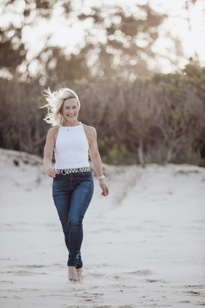 Christine McDougall walking through a sandy beach path