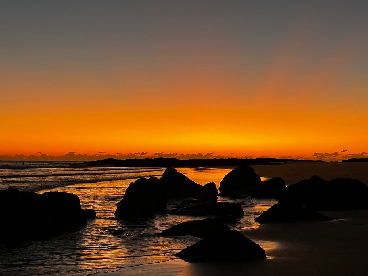 Golden sunrise over rocks and ocean