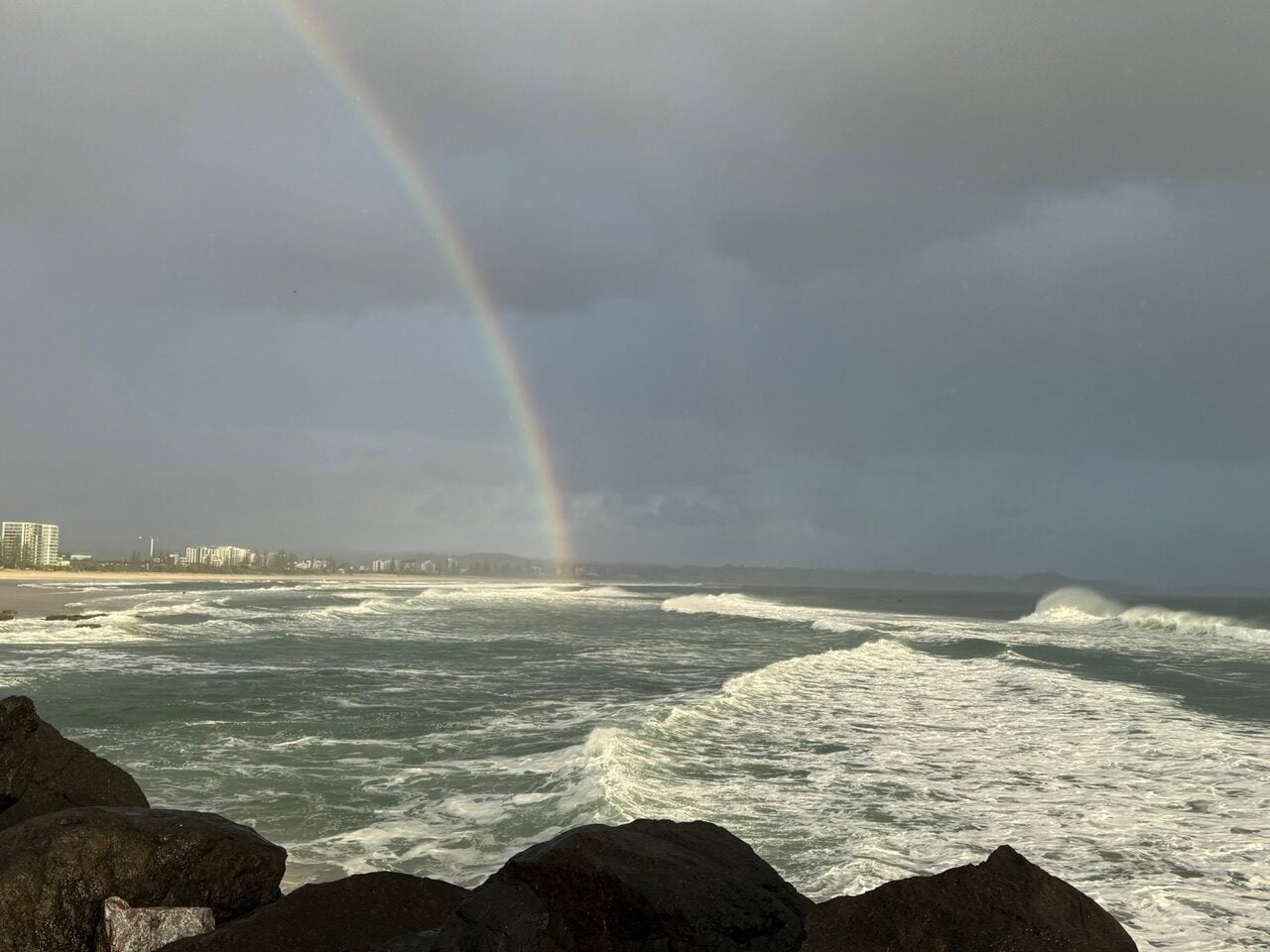 rainbow over a stormy beach