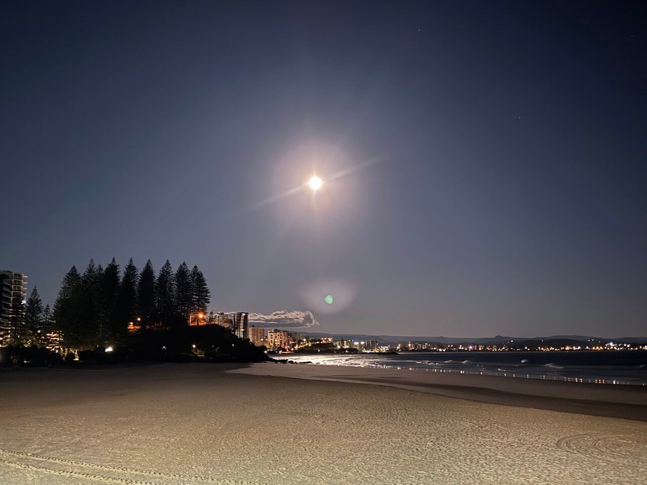 full moon setting over ocean
