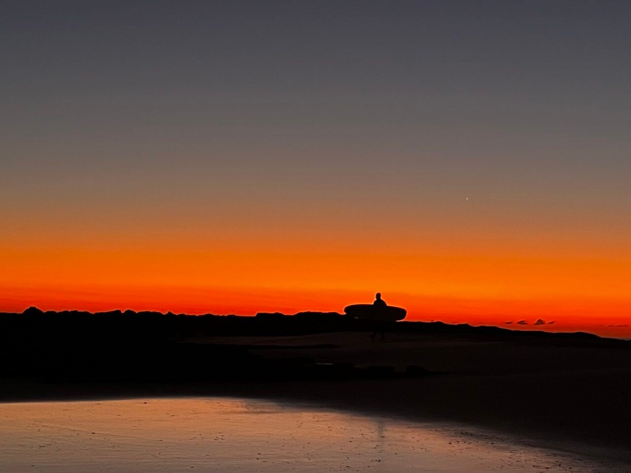 Golden sunrise with surfer silhouette