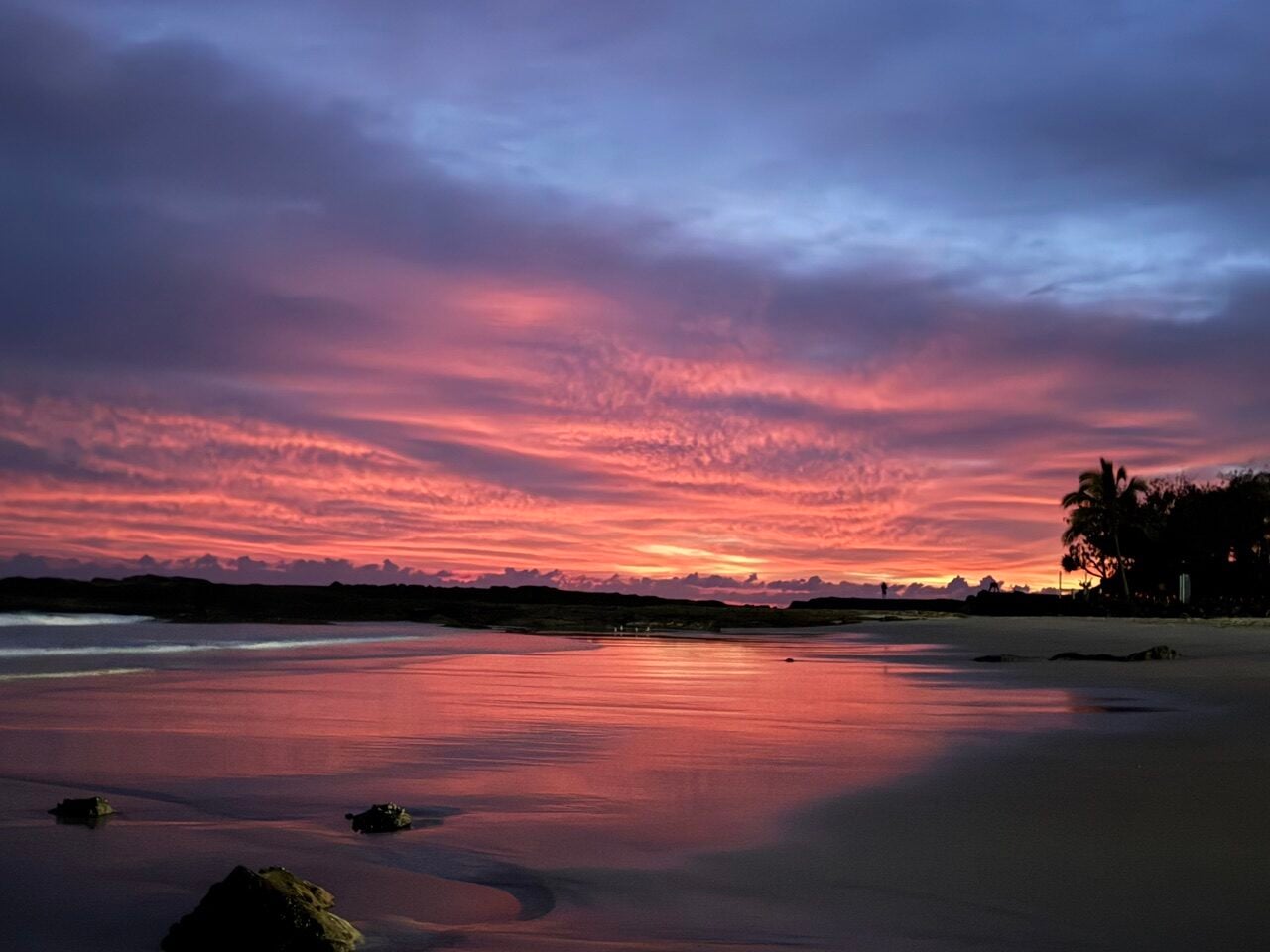 pinks and blues of a sunrise with reflections off the sand