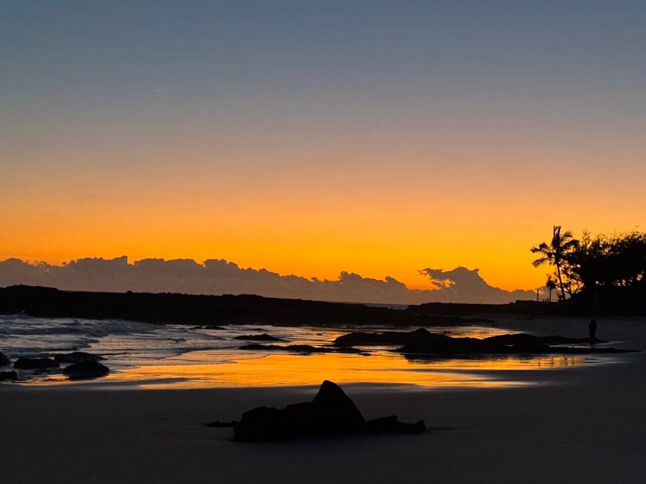 golden sunrise over rocks and beach