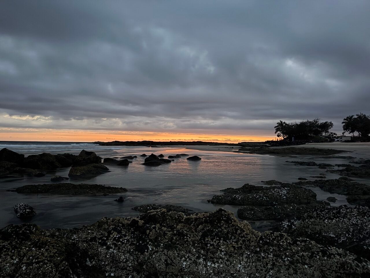 sunrise, rocks, beach and grey clouds